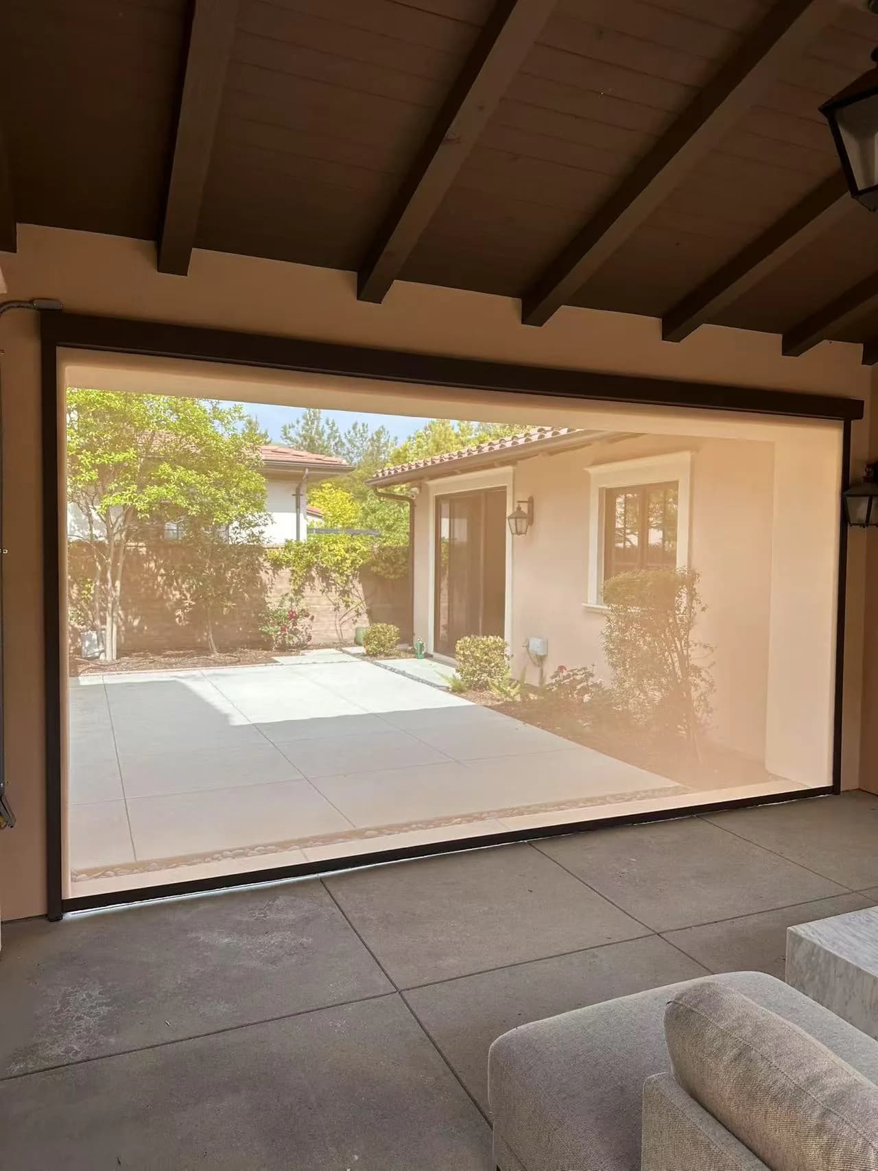Exterior shade spanning a covered outdoor opening beside patio furniture.