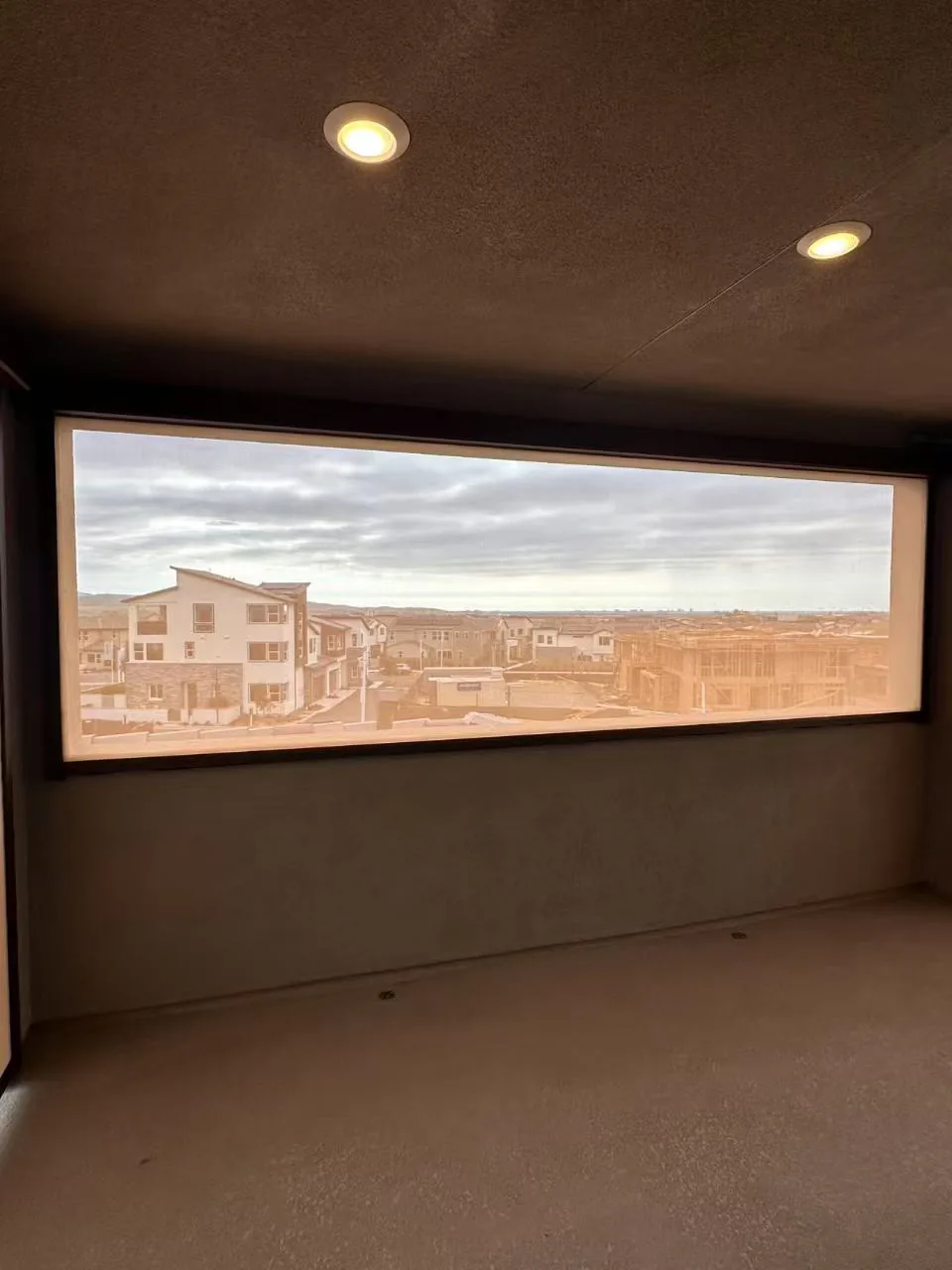 Exterior shade fabric lowered across an opening with daylight visible beyond.