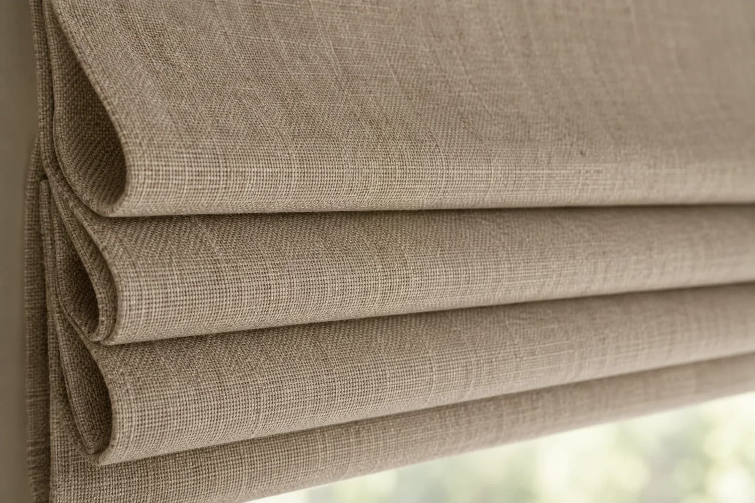 Close-up of textured Roman shade fabric folds.