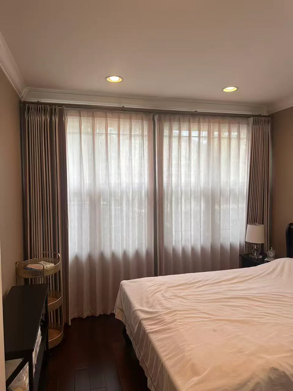 Custom drapery and sheer panels installed across a bedroom window.