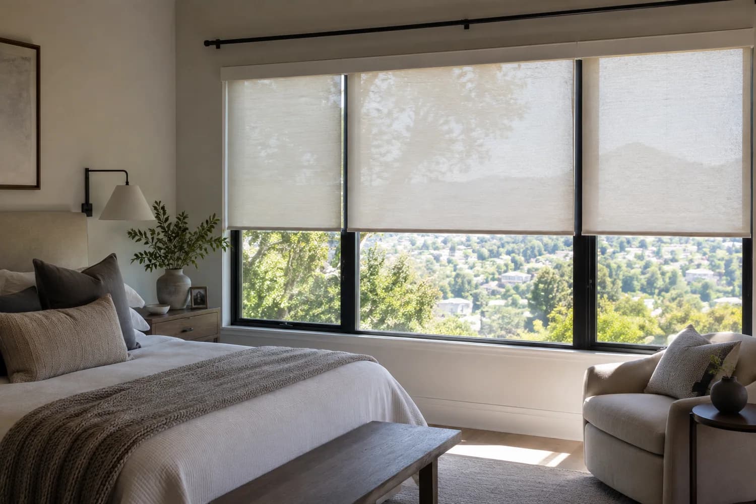 Light-filtering roller shades installed in a bedroom.