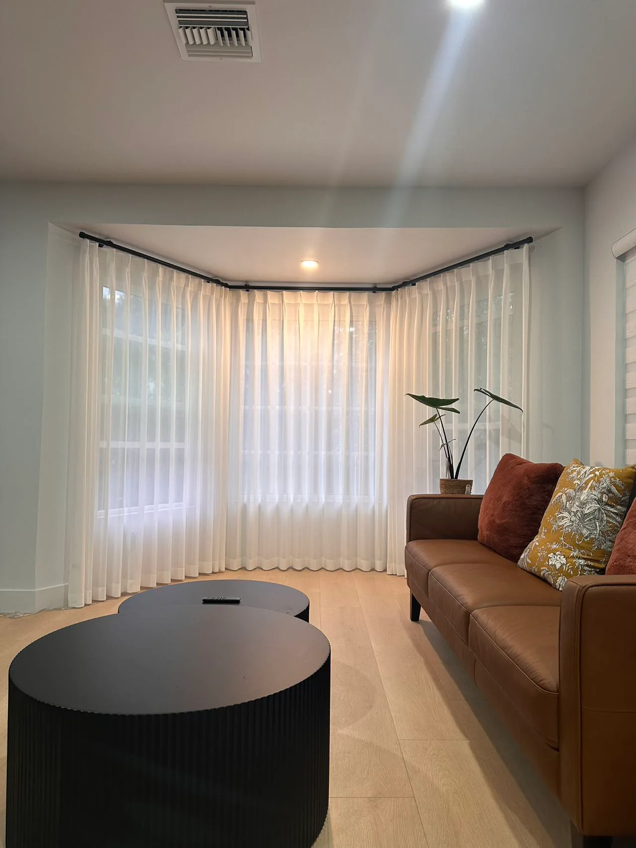 Soft sheer curtains framing a living room window with filtered daylight.