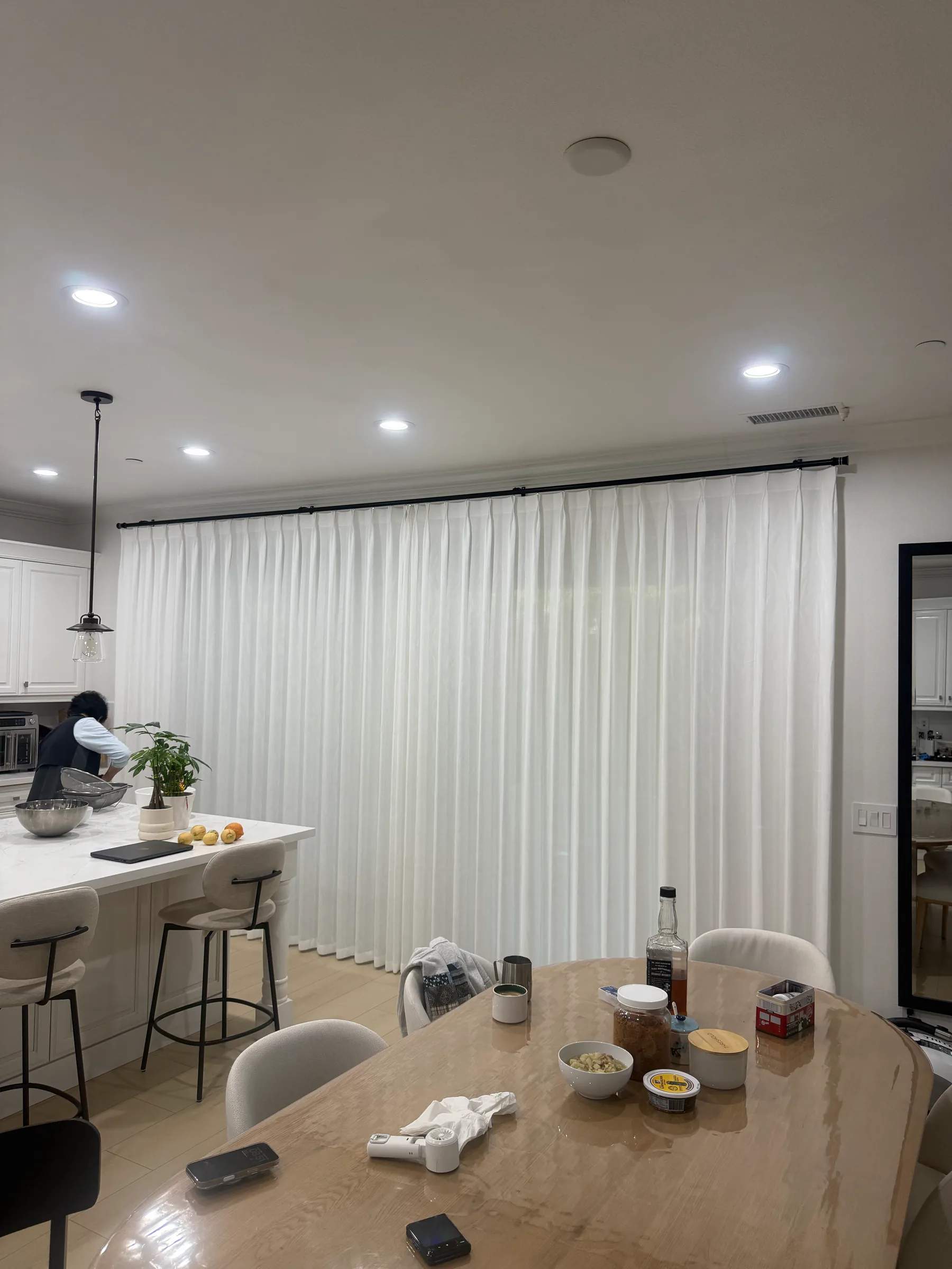 Sheer curtain panels adding soft texture along a bright window wall.