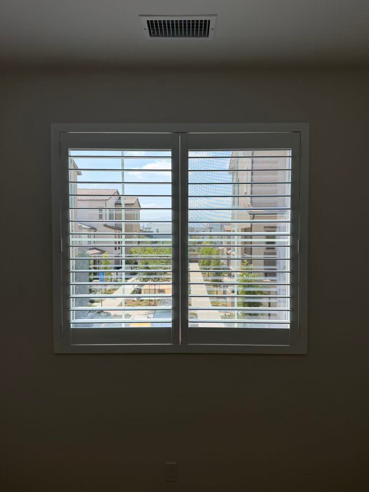Close-up view of white plantation shutters in a completed Chino project