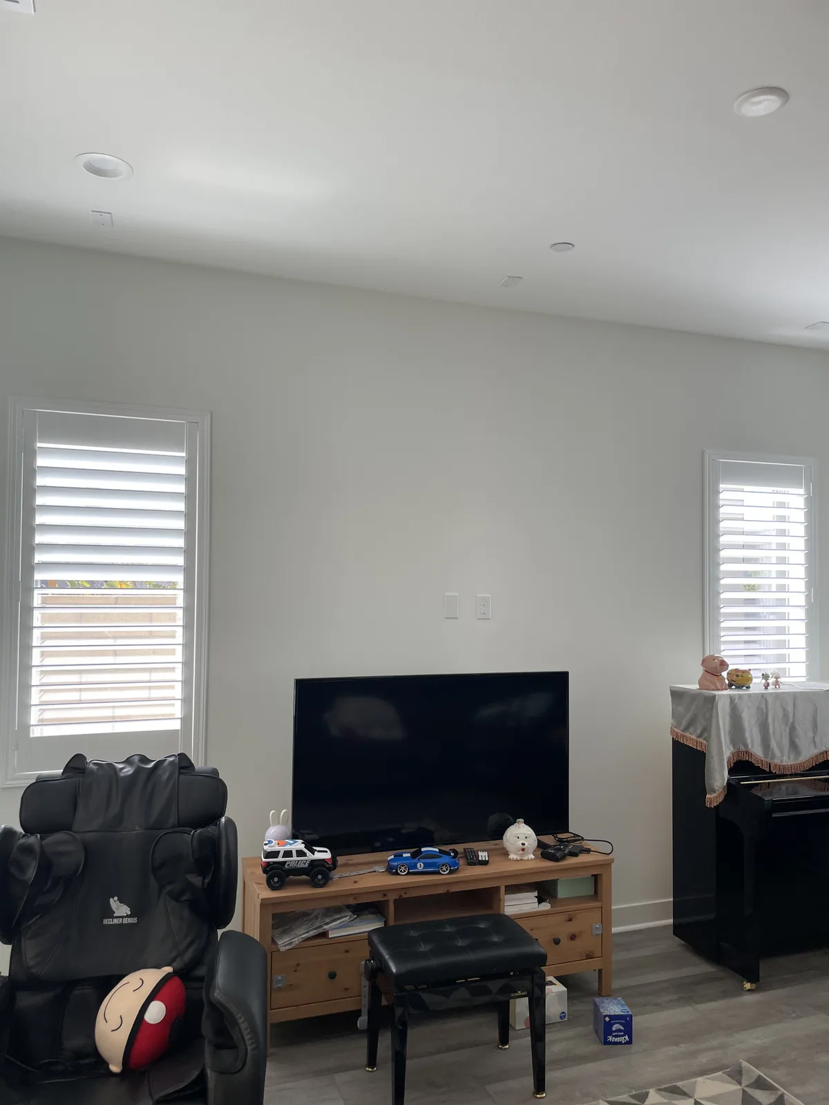 White plantation shutters on separate windows in a Cadence Park living room