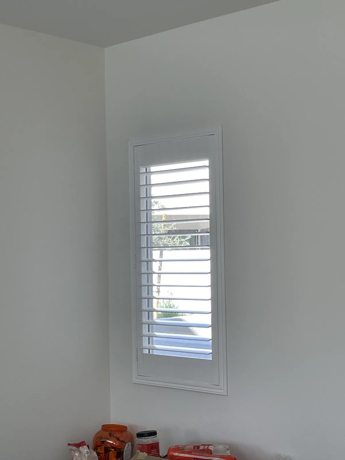 White plantation shutter on a narrow window in a Cadence Park home