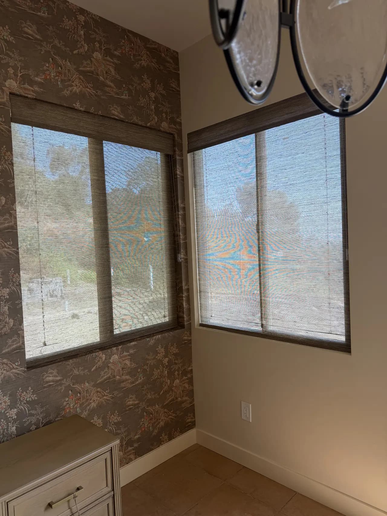 Coordinated woven wood shades on adjacent windows in a Newport Beach room