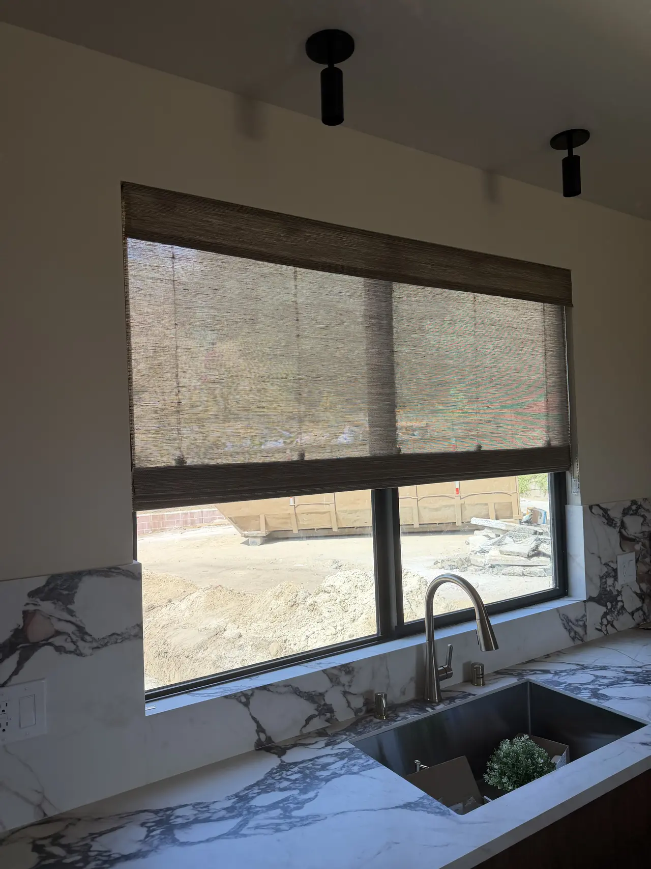 Woven wood shade installed above a kitchen window in Newport Beach